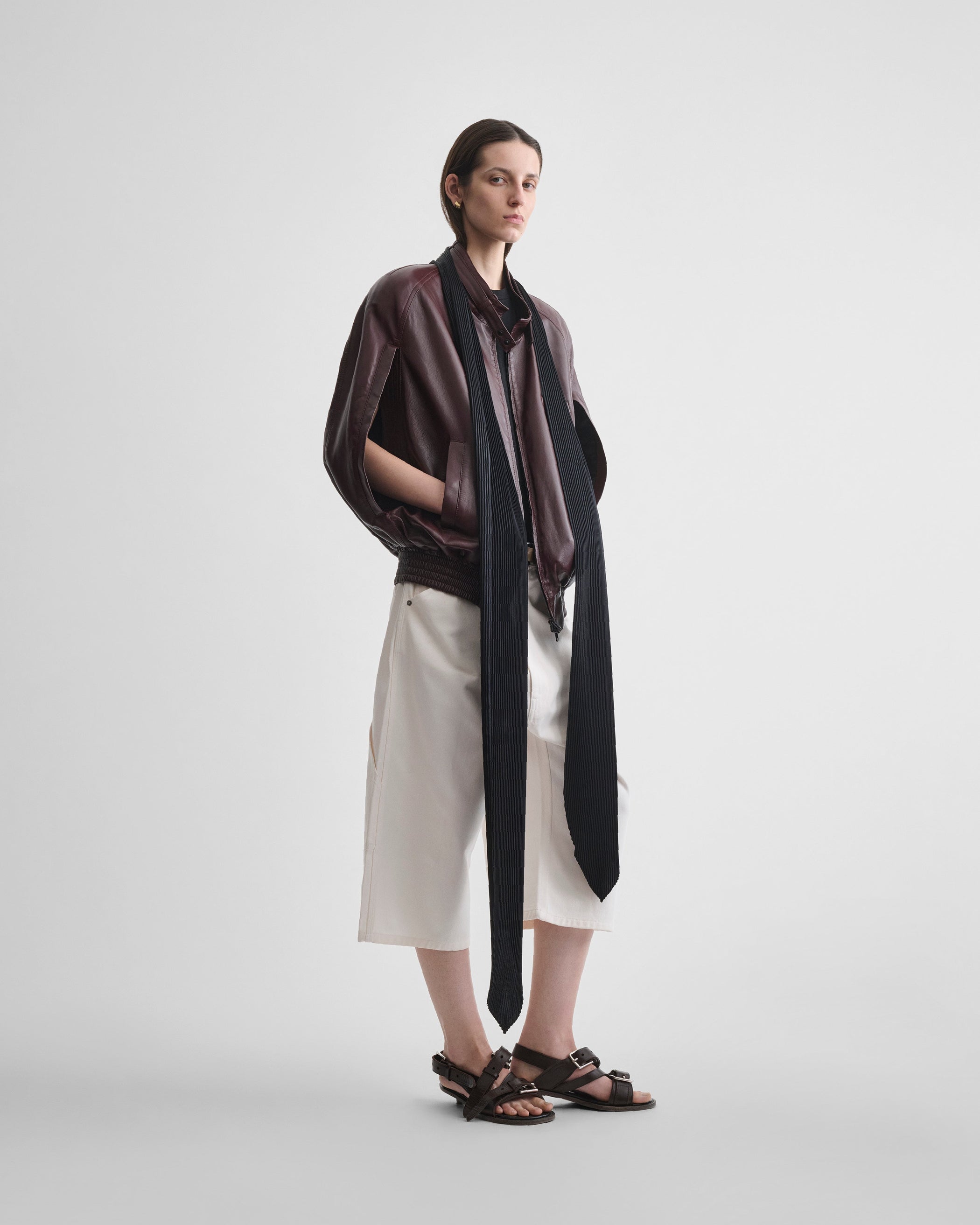 Angled front view of model wearing LONG PLEATED SCARF in black silk