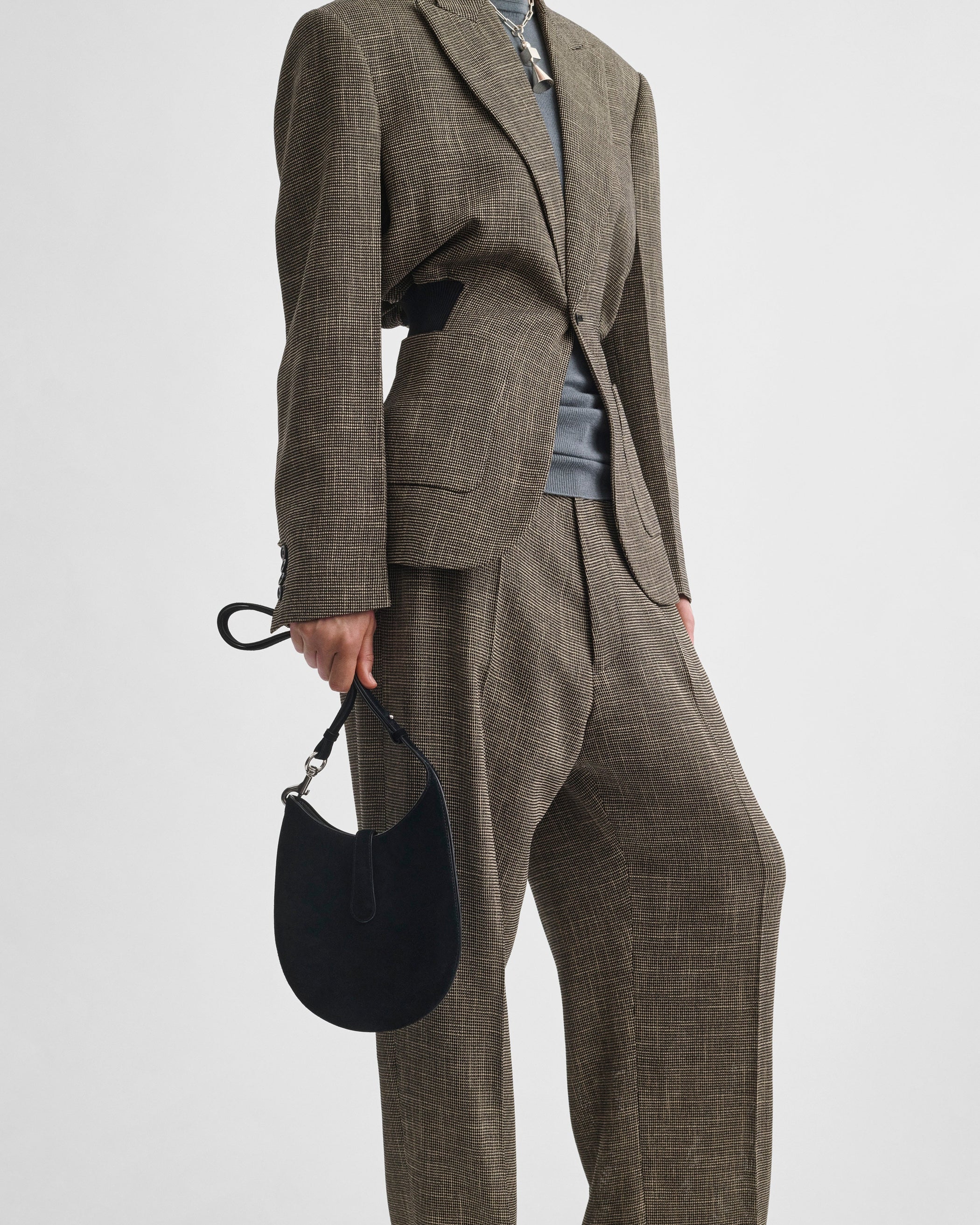 Image of model holding MINI BEAN SLING in black suede