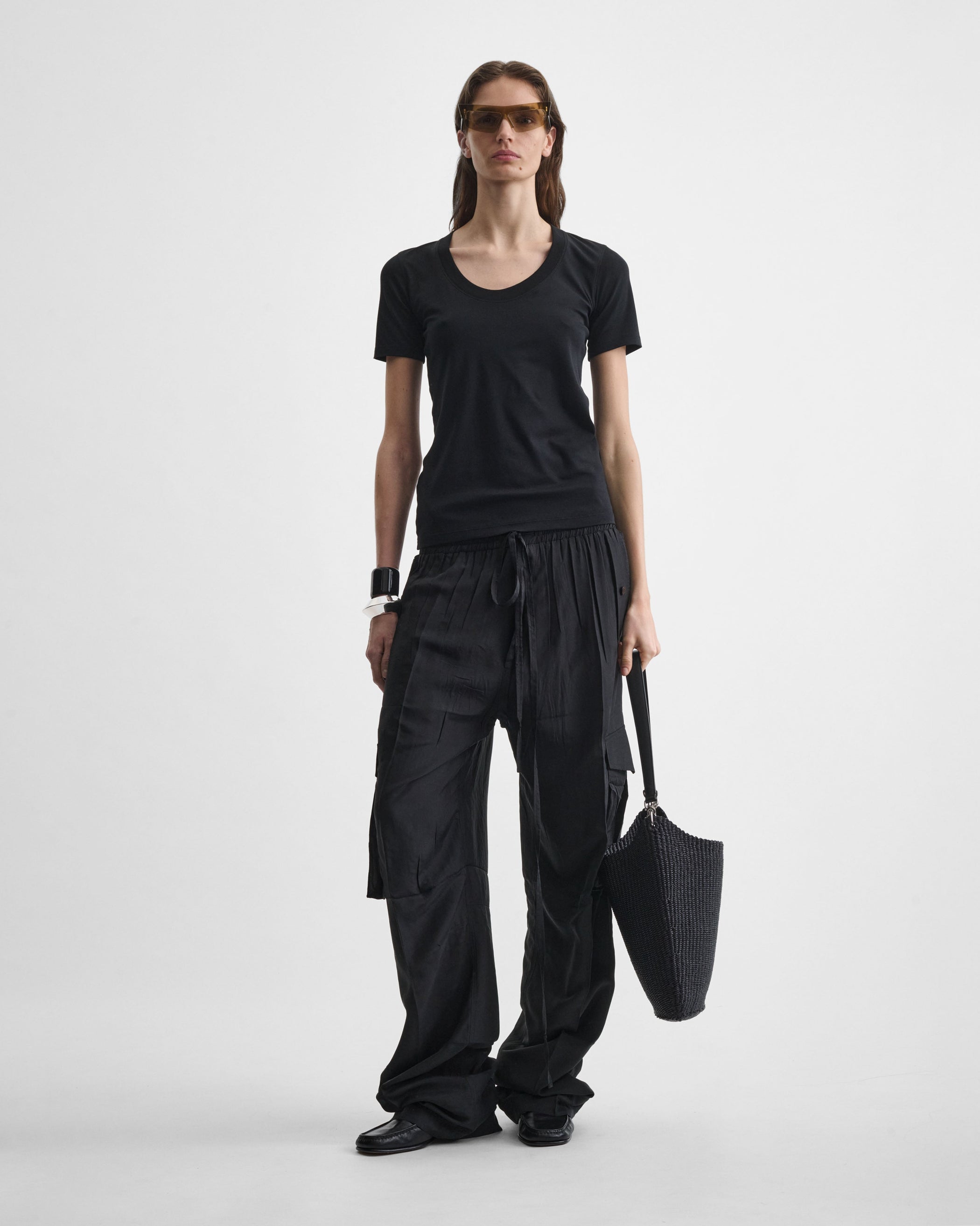 View of model holding SMALL SLOPE SLING in black woven viscose