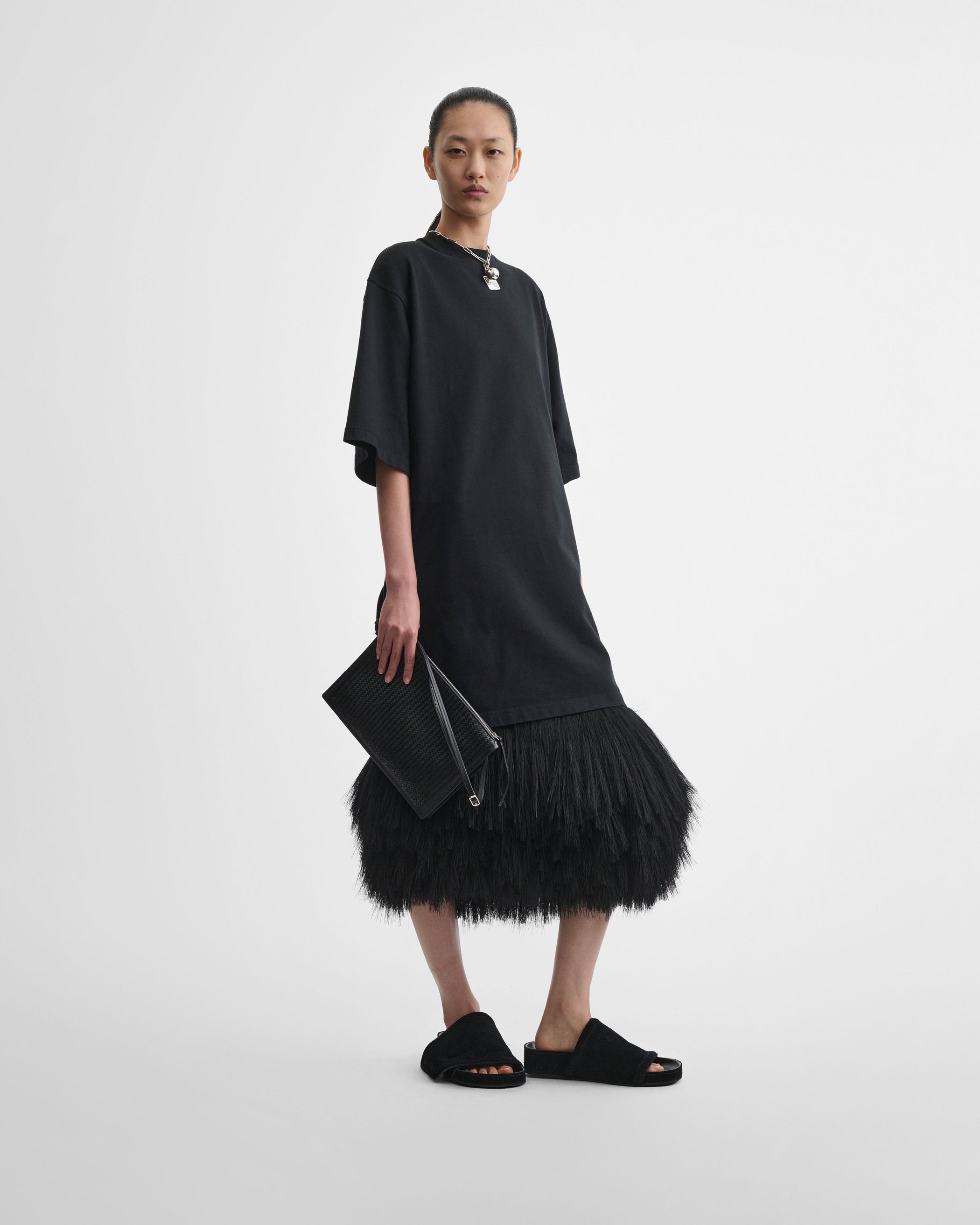 View of model holding GLOVE POCHETTE in black woven leather