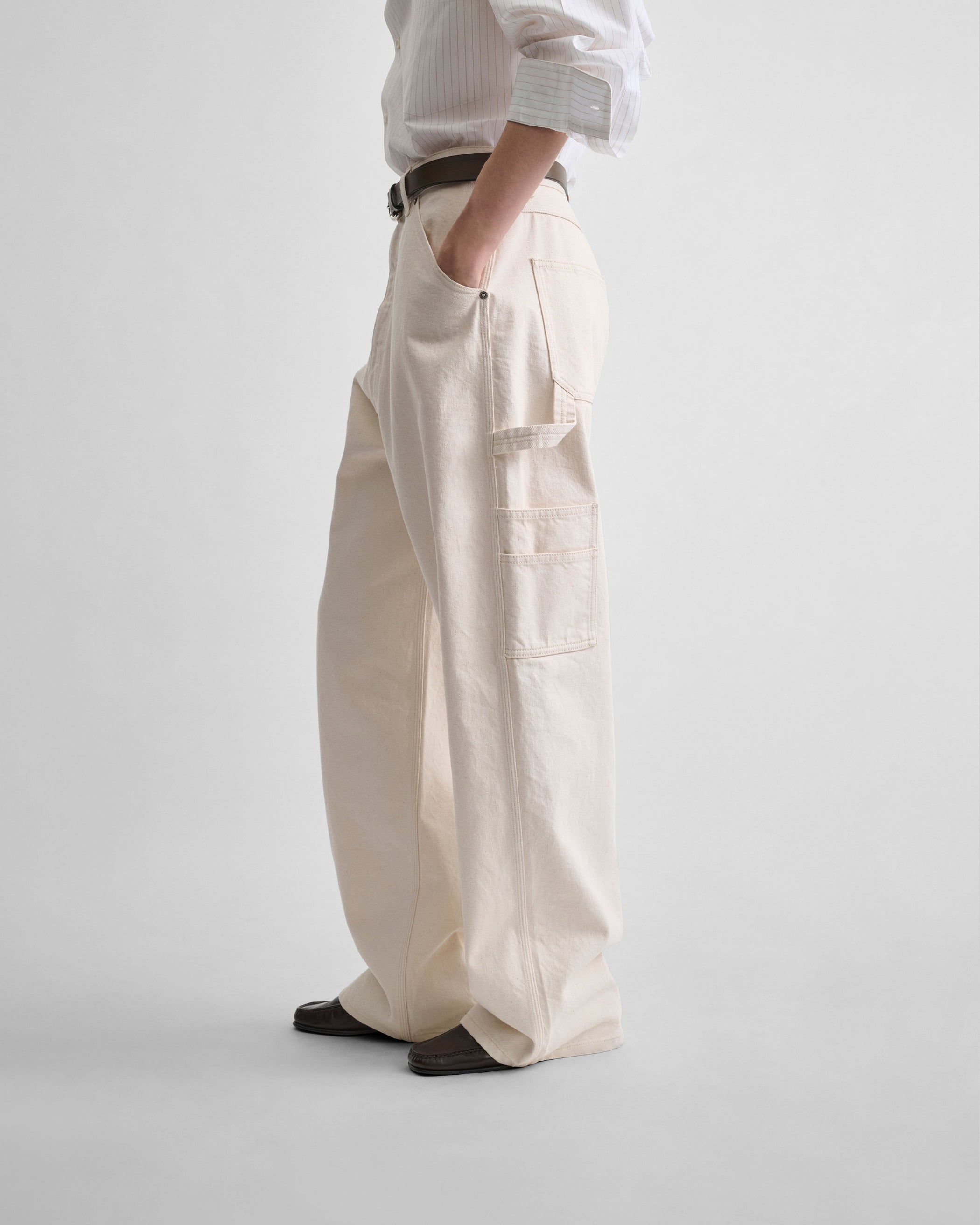 Side view of model wearing CARPENTER JEANS in cream cotton