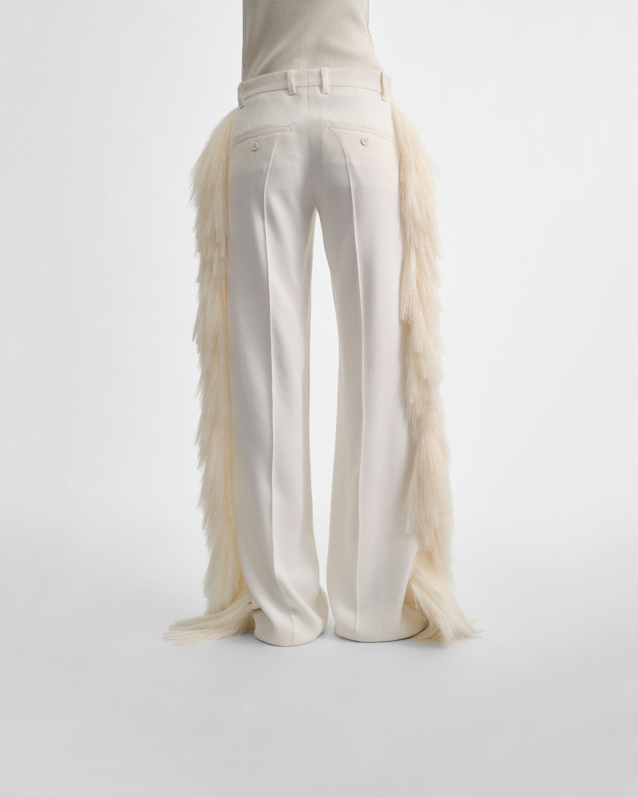 Back view of model wearing FRINGED TROUSERS in vanilla viscose