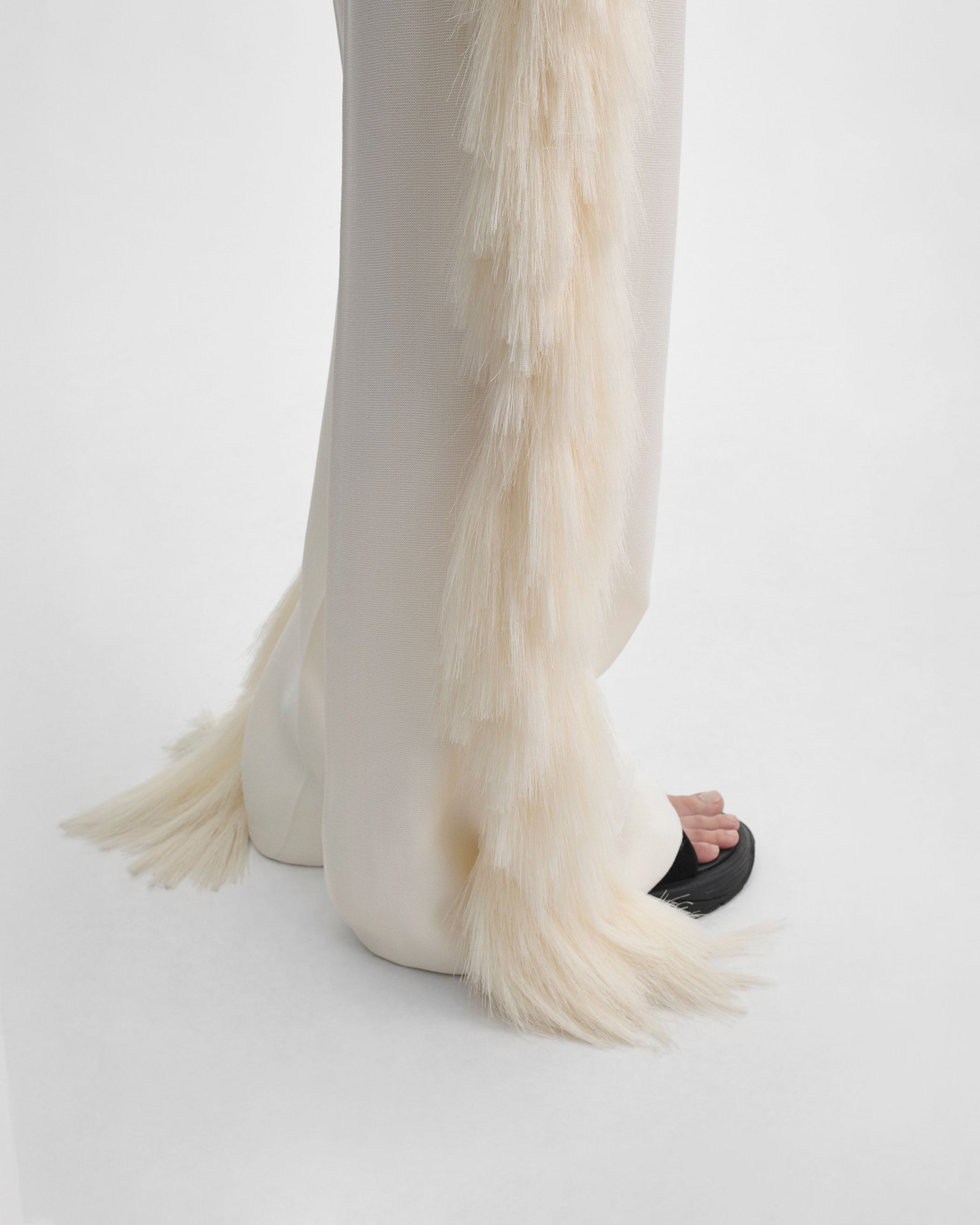 Side detail view of model wearing FRINGED TROUSERS in vanilla viscose