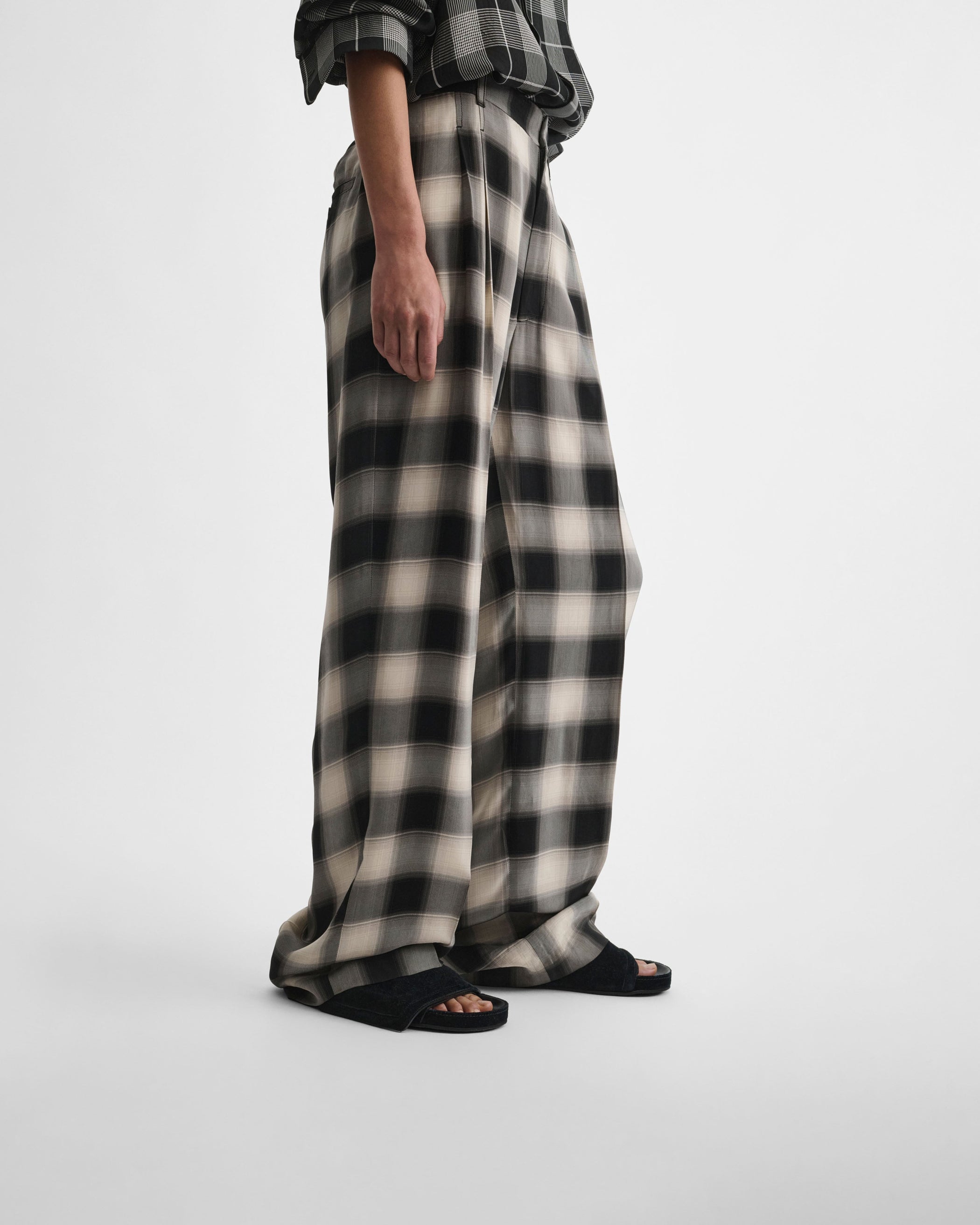 Side view of model wearing DOUBLE PLEAT TROUSERS in salt and pepper woven viscose