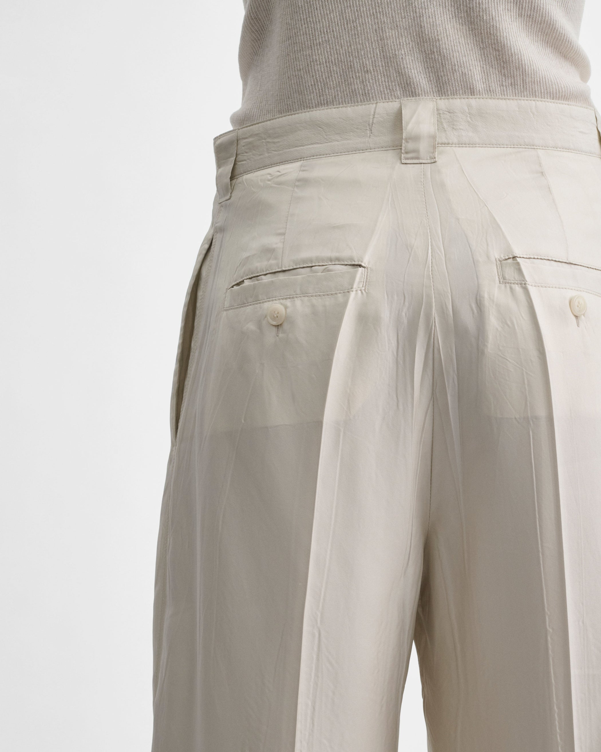 Back detail view of model wearing CHINO TROUSERS in salt technical twill