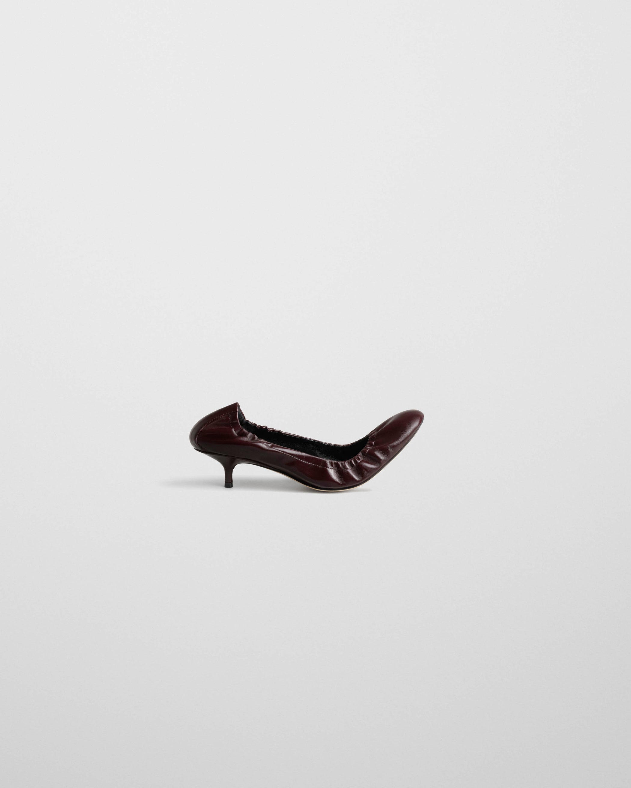 Flat side view of LOW PUCKER PUMP 45 in oxblood leather