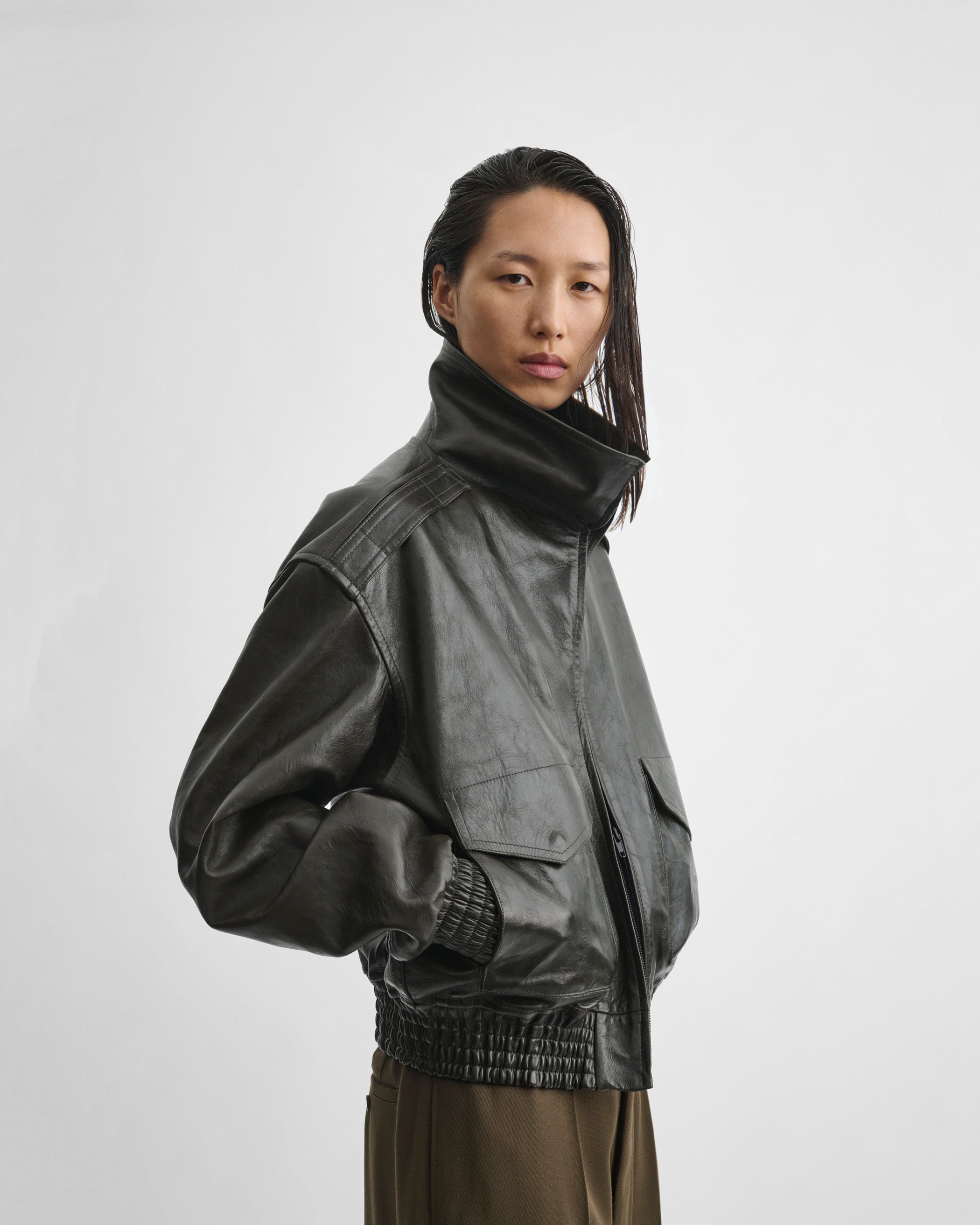 Side close up model view of model wearing the AVIATOR JACKET in dark emerald leather