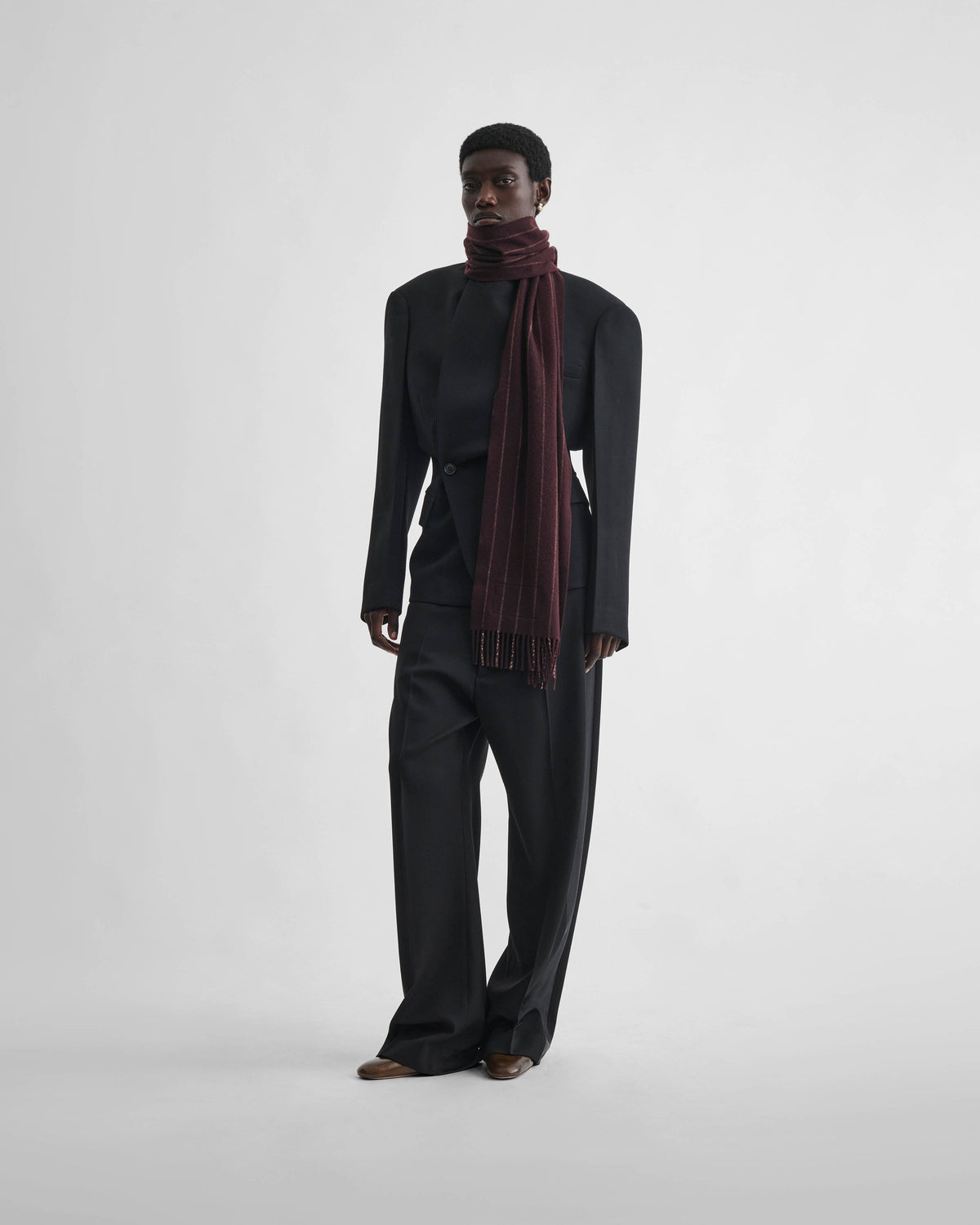 Front view of model wearing PINSTRIPE SCARF in maroon cream wool