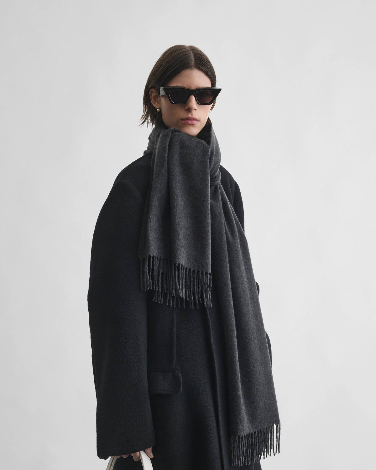 Front view of model wearing BIG FRINGE SCARF in dark grey wool