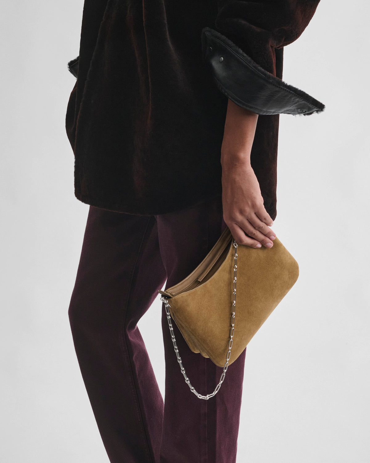 Side view of model wearing SMALL GIG BAG in caramel suede