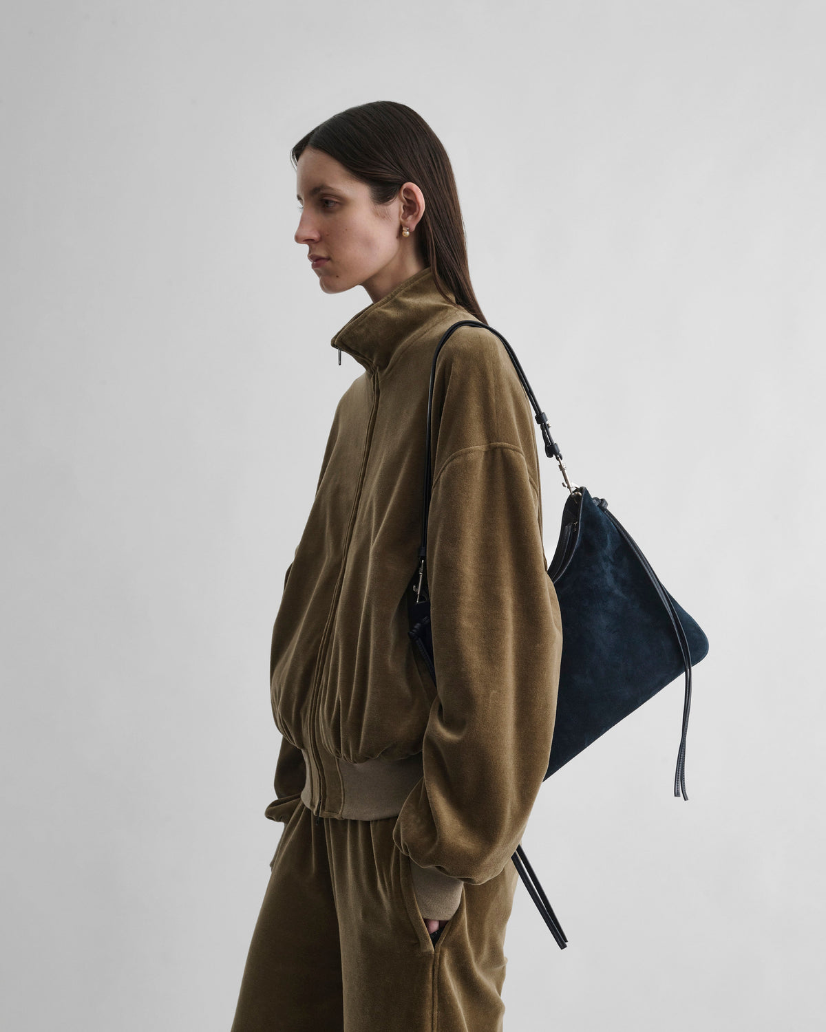 Side view of model wearing GIG BAG in navy leather