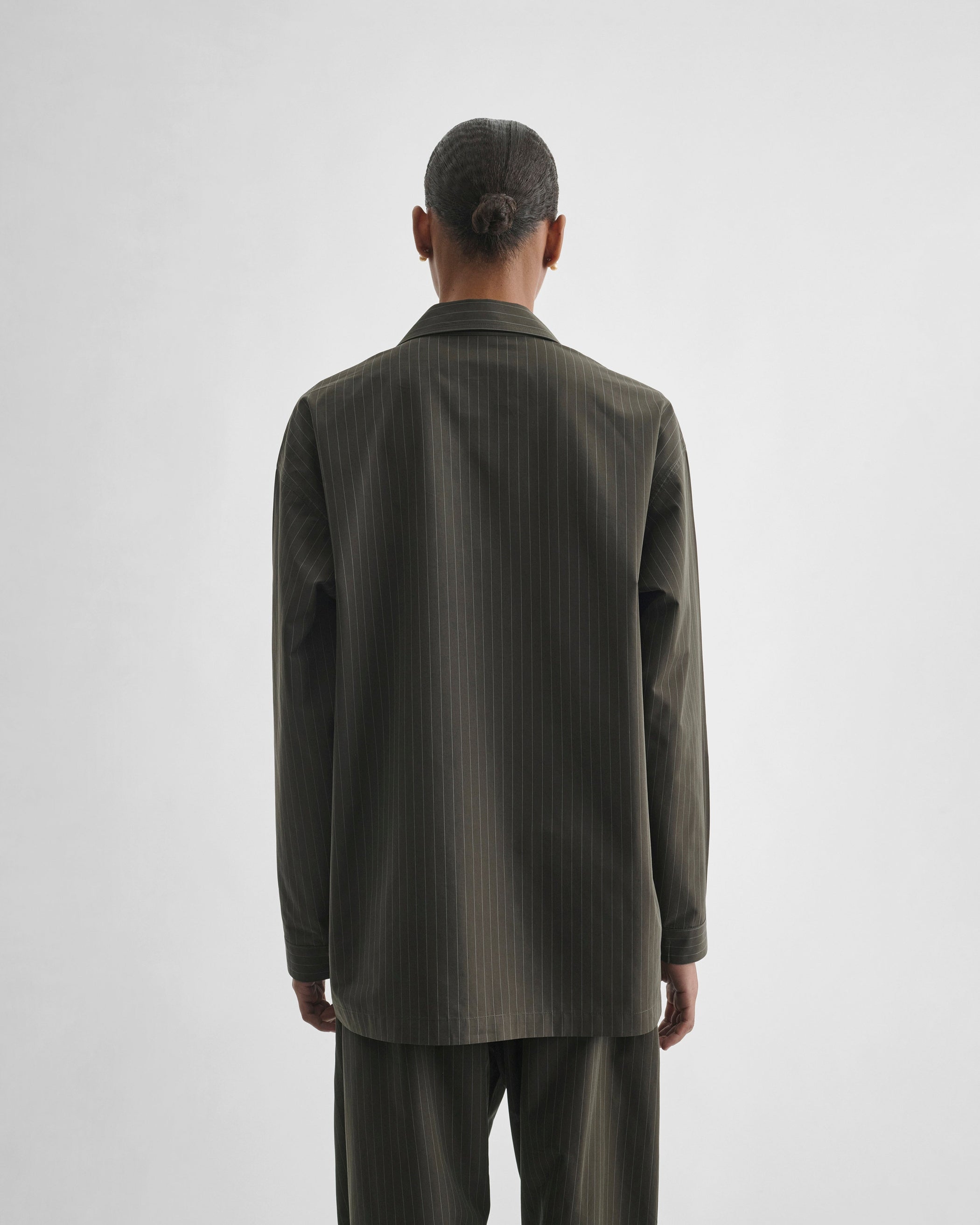 Back view of model wearing PYJAMA SHIRT in dark khaki cotton