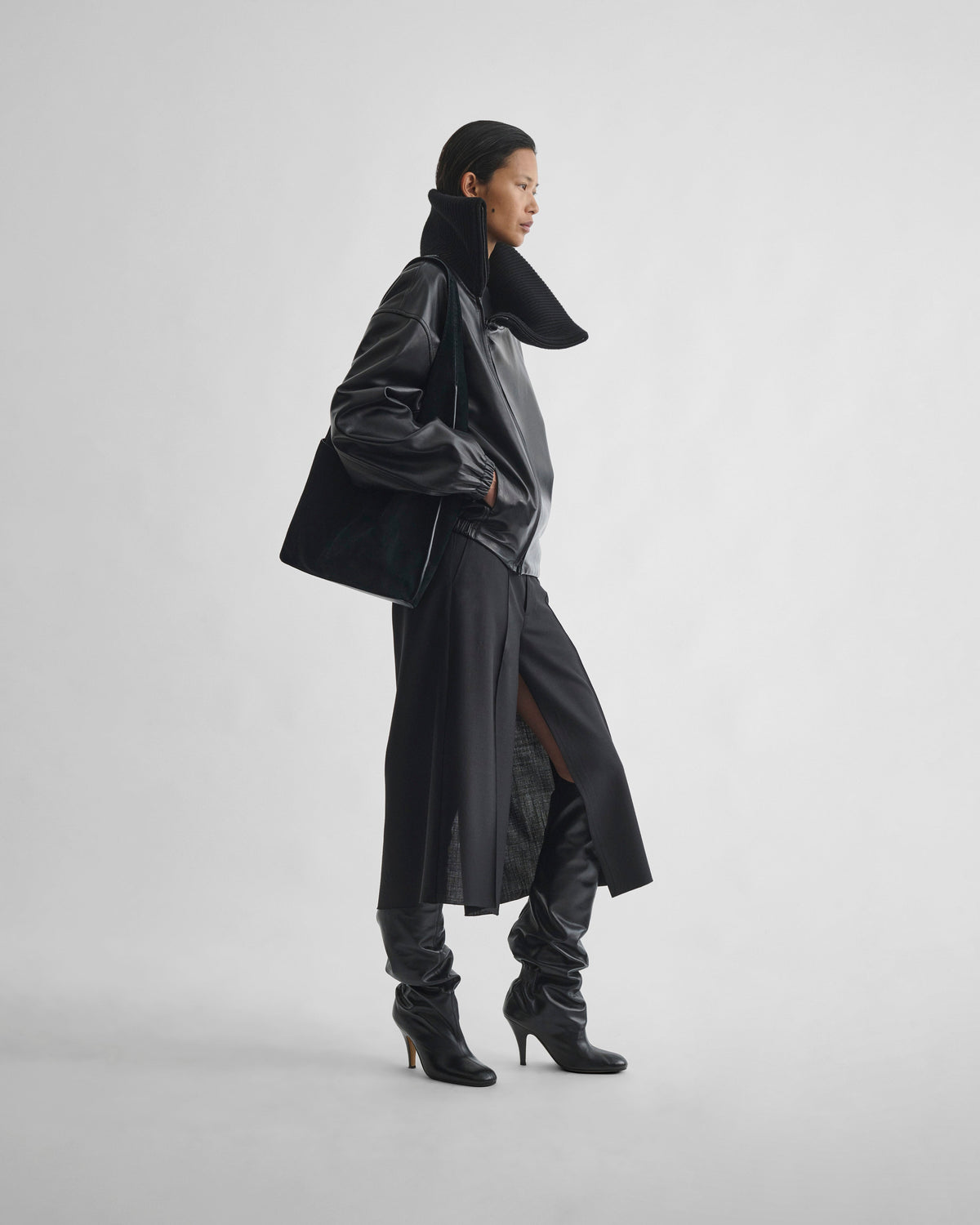 Side view of model wearing SPLIT SKIRT in black wool