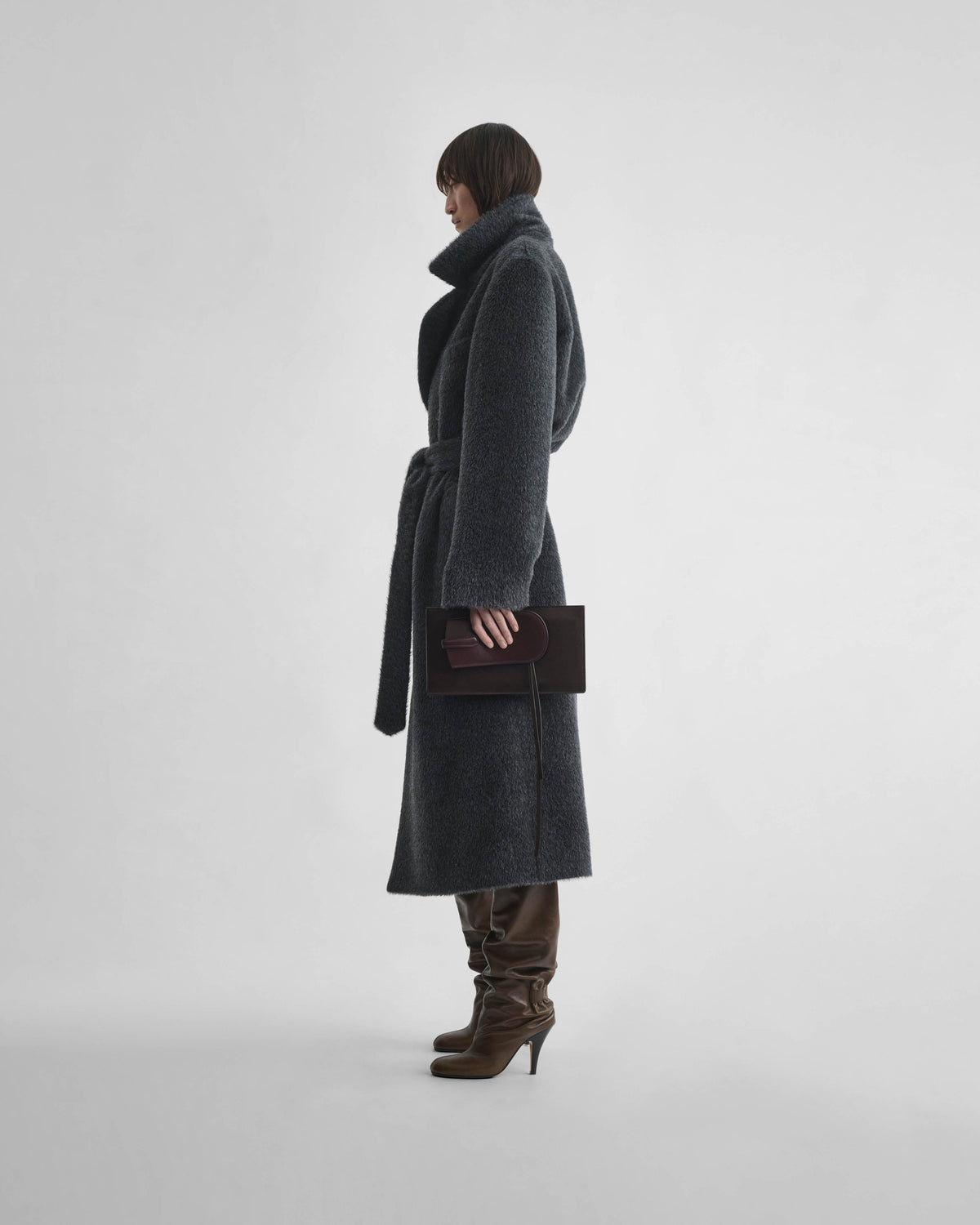 Side view of model wearing BELTED TEDDY COAT in ash shearling