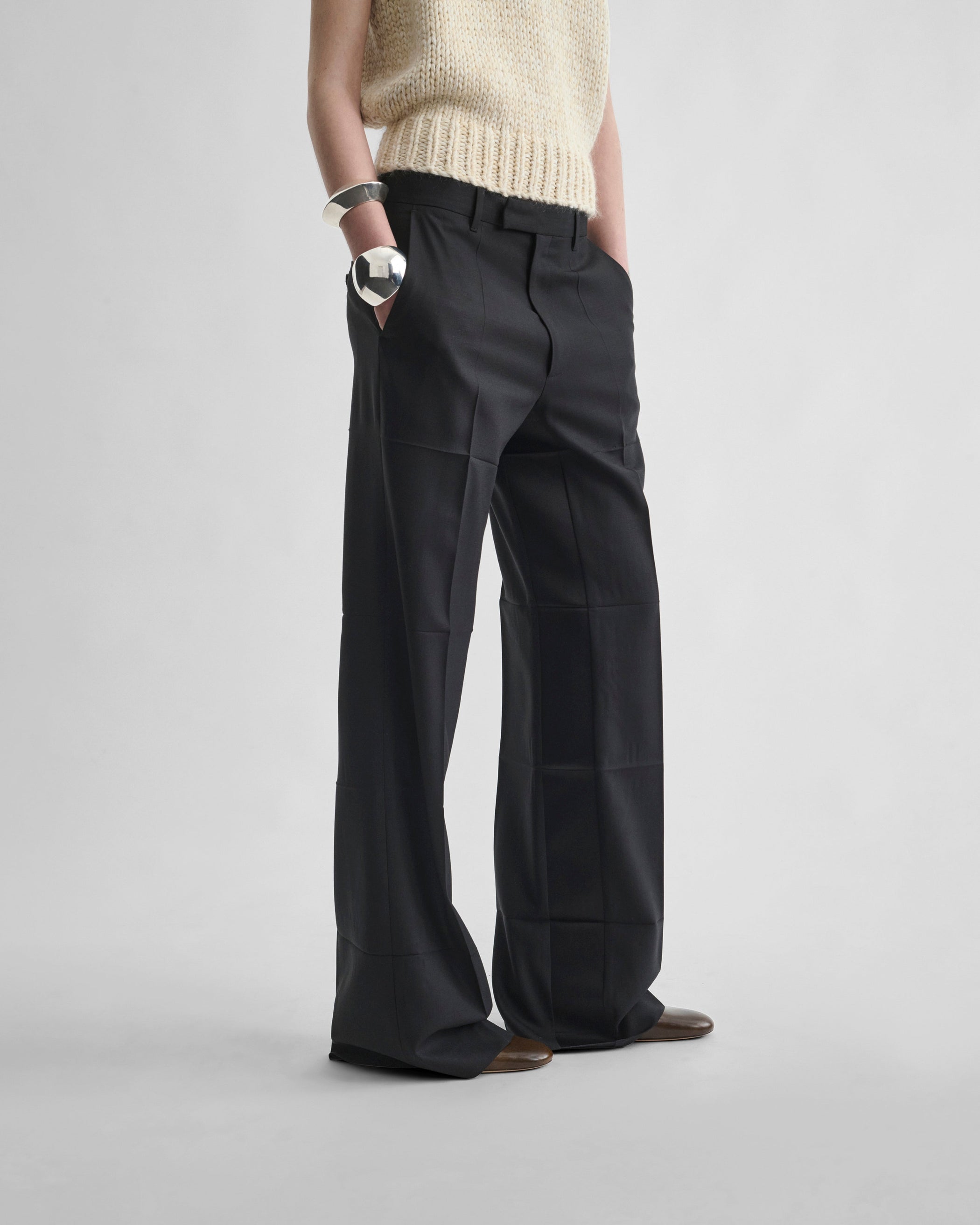 Angled front view of model wearing TUX BOYISH TROUSERS in black wool