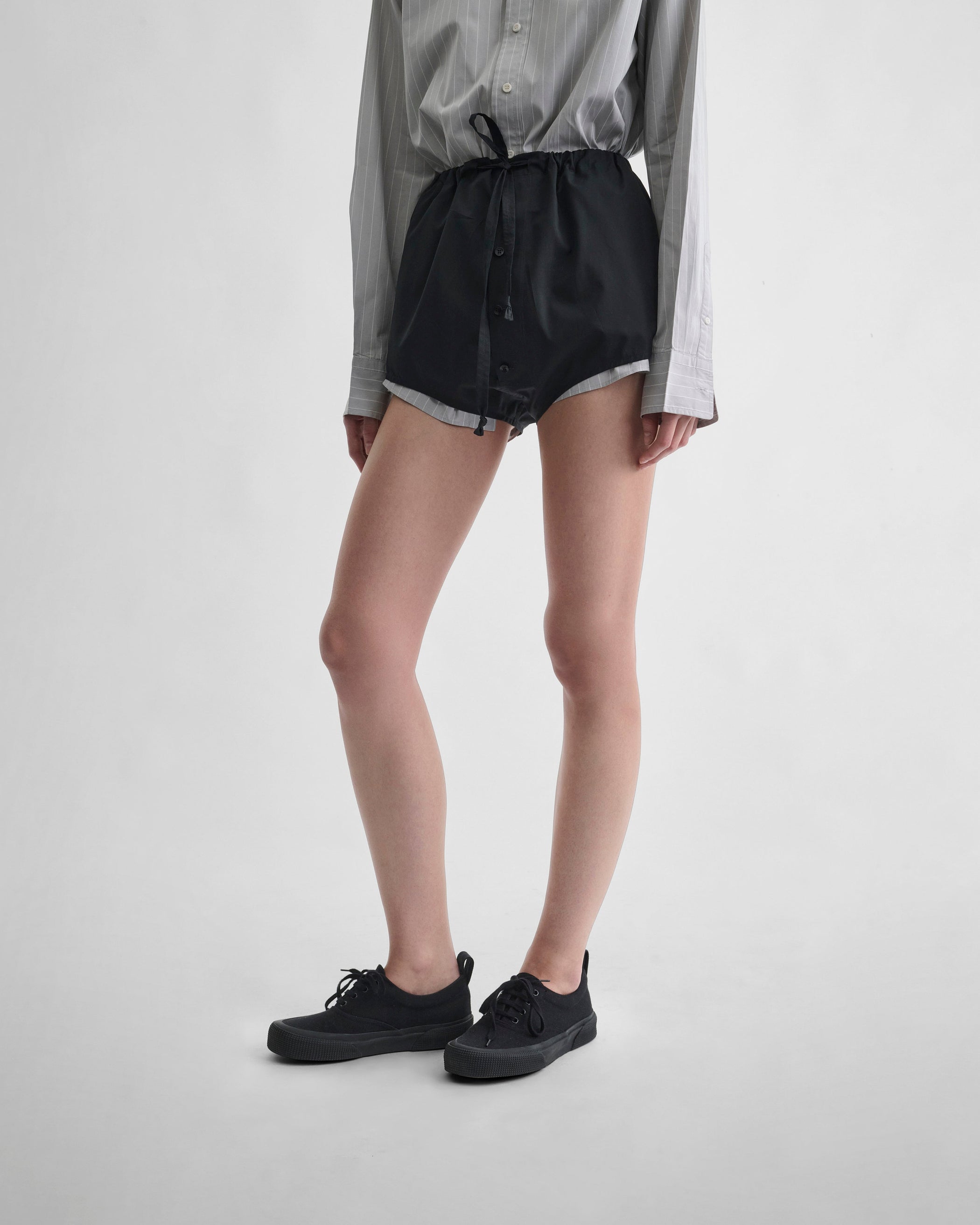 Front detail view of model wearing HIGH SHORTS in black cotton
