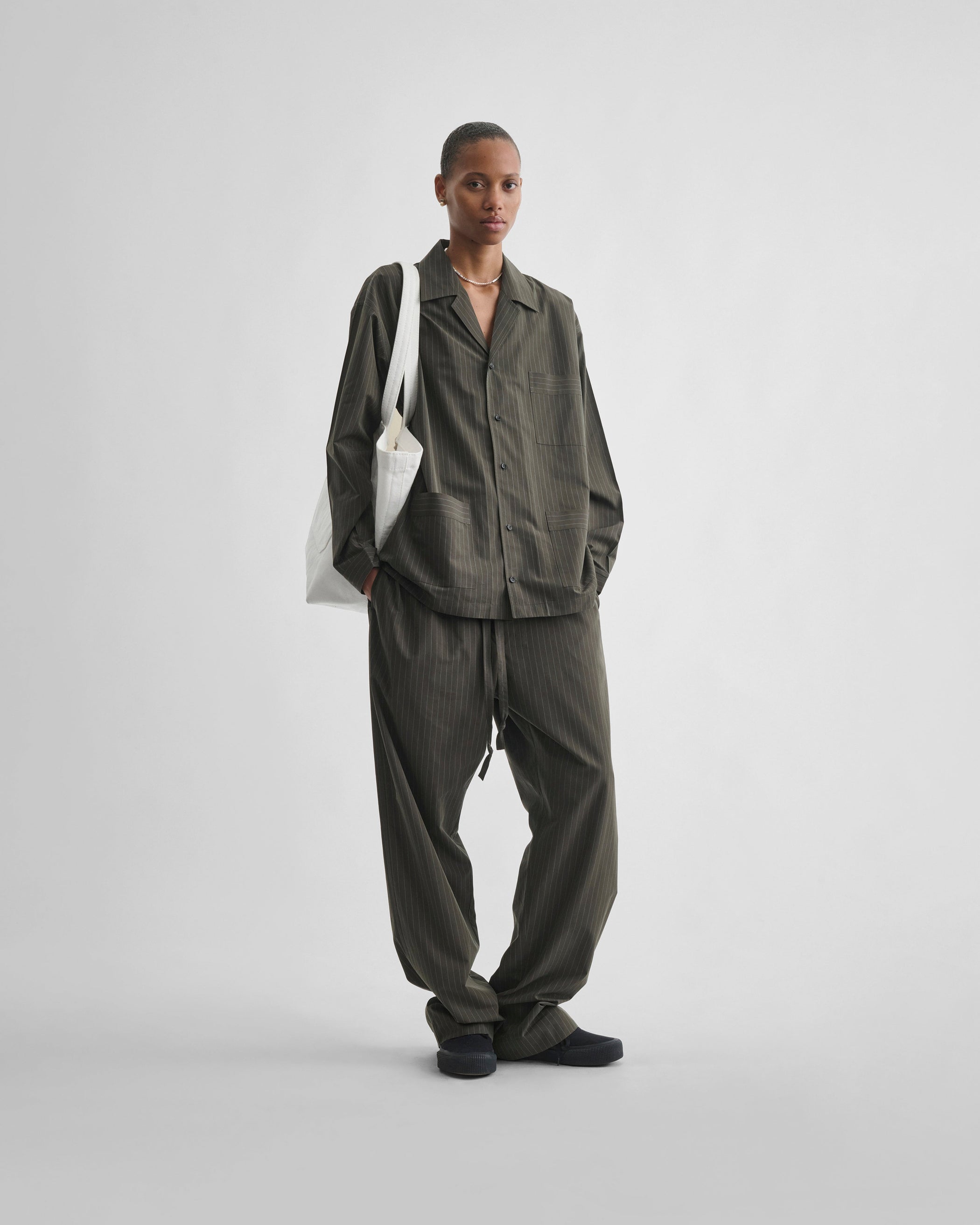 Front view of model wearing PYJAMA TROUSERS in dark khaki cotton