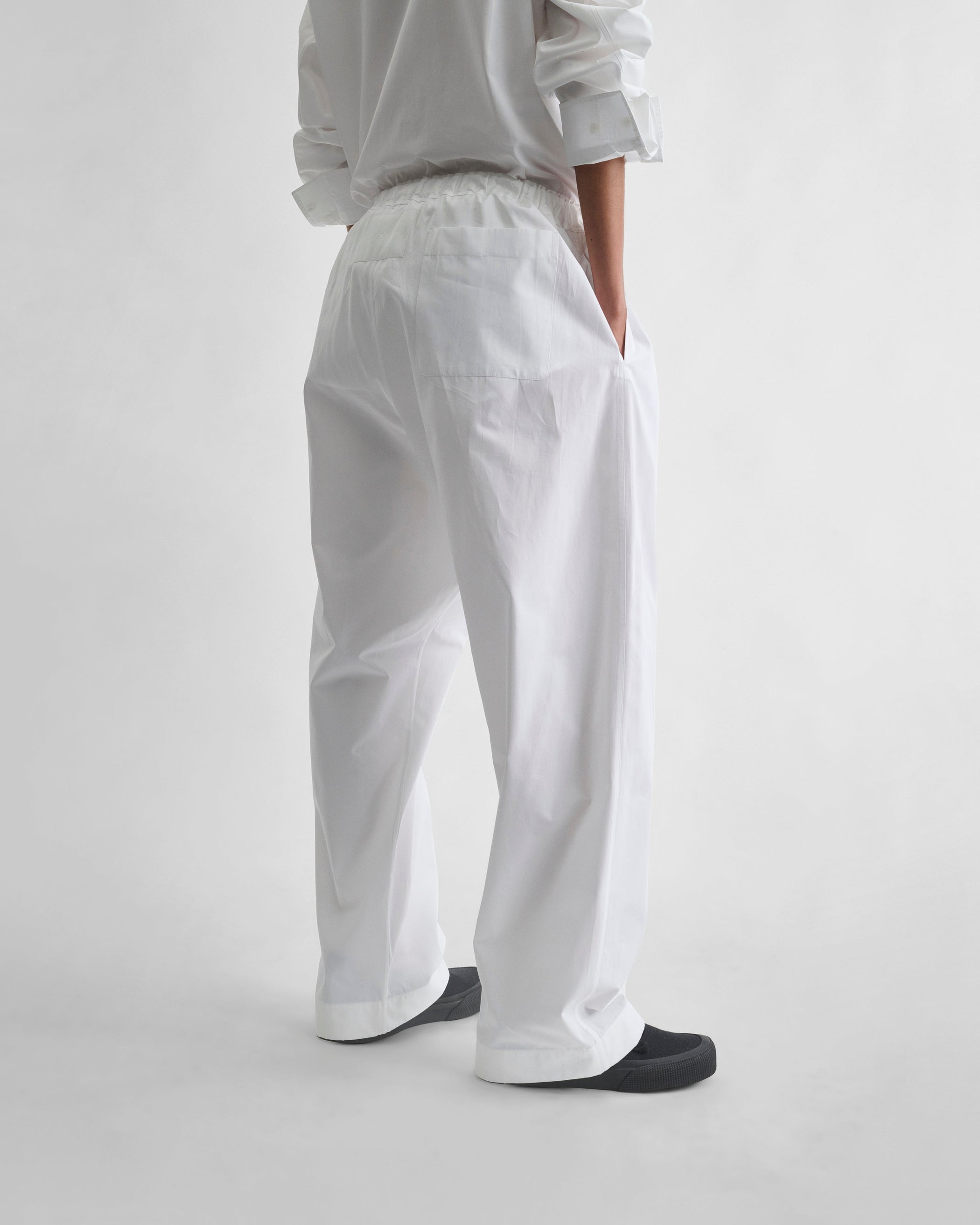 Back view of model wearing PYJAMA TROUSERS in white cotton