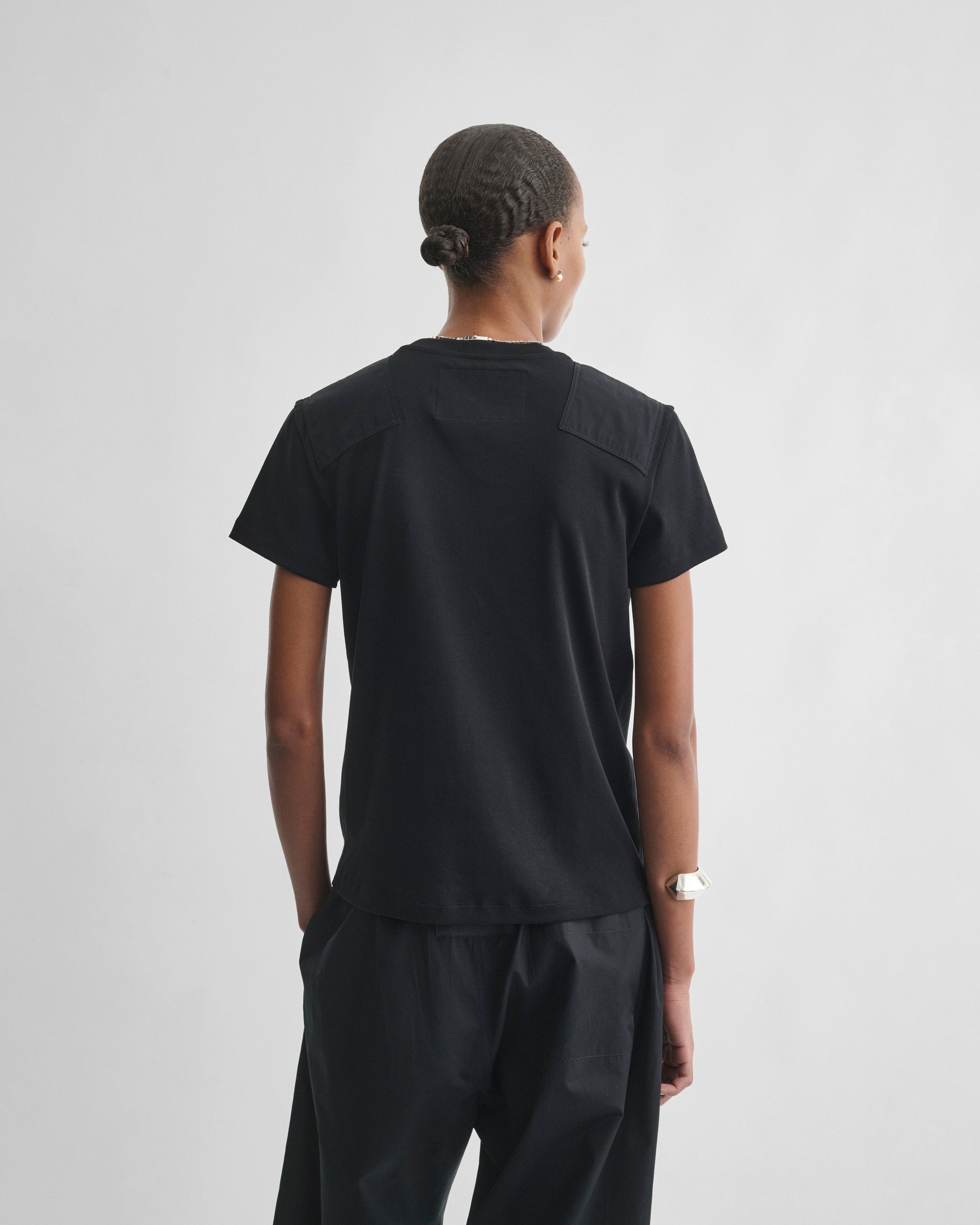 Back view of model wearing PATCH T-SHIRT in black cotton