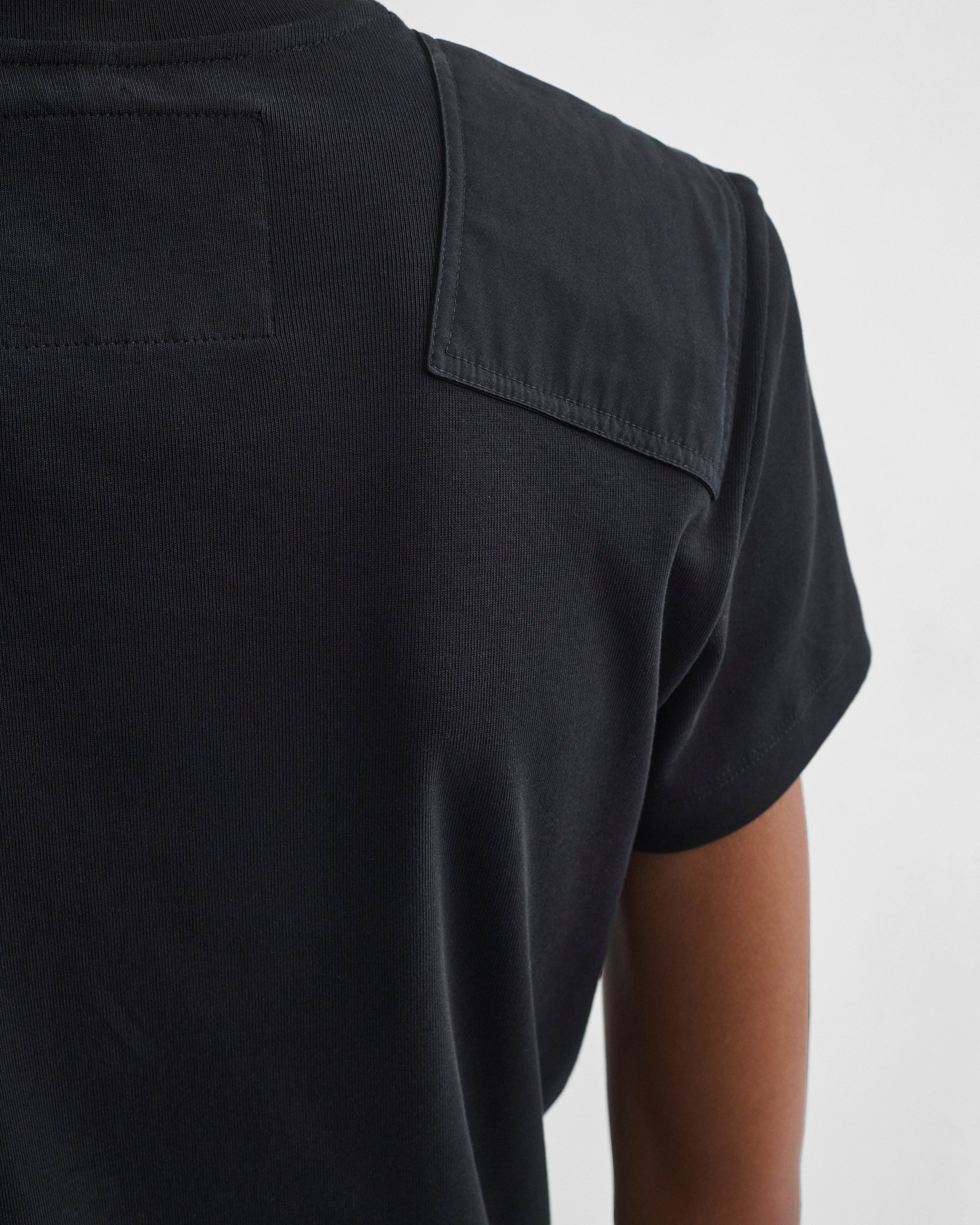 Detail view of model wearing PATCH T-SHIRT in black cotton