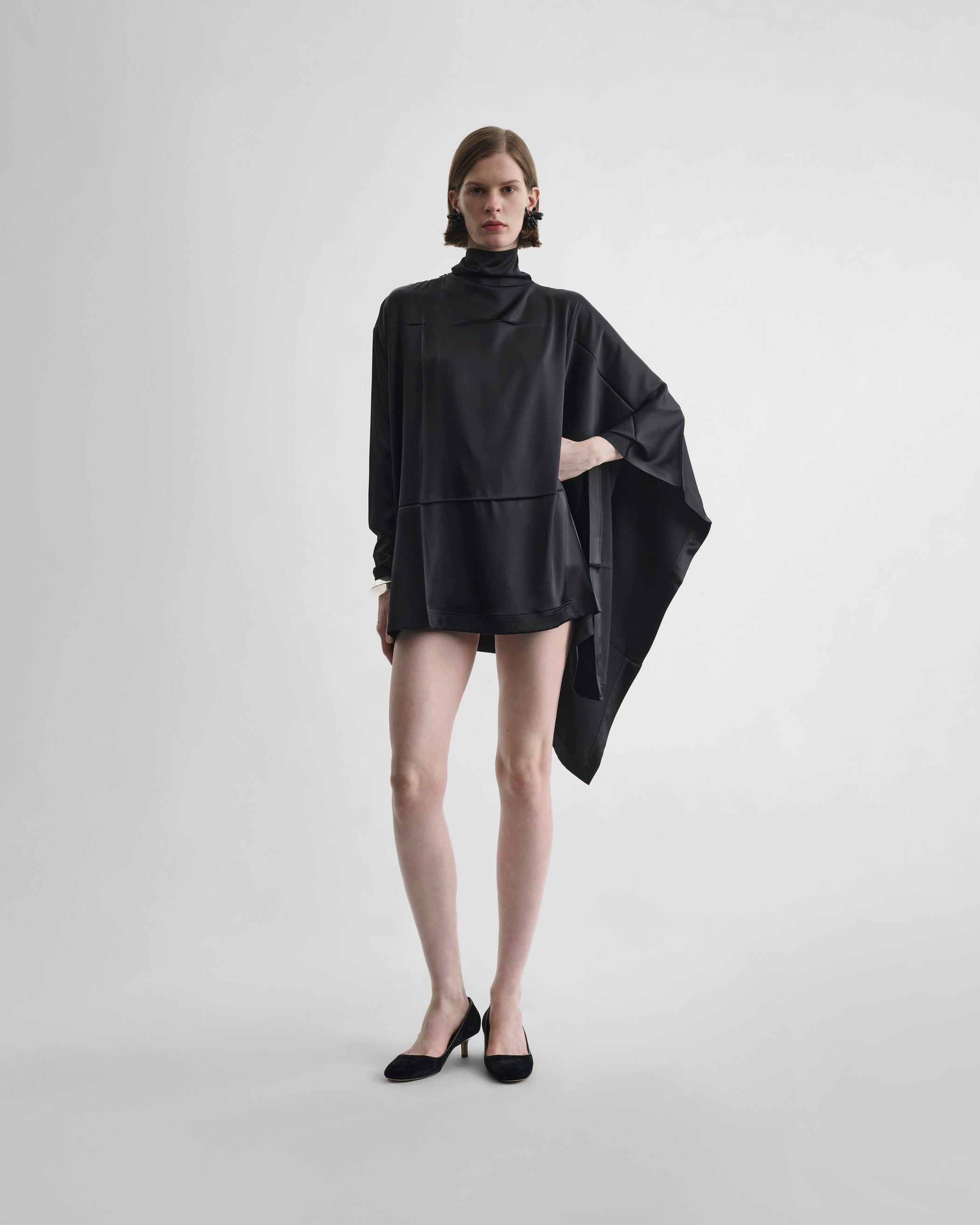 Front view of model wearing CAPED TOP in black silk