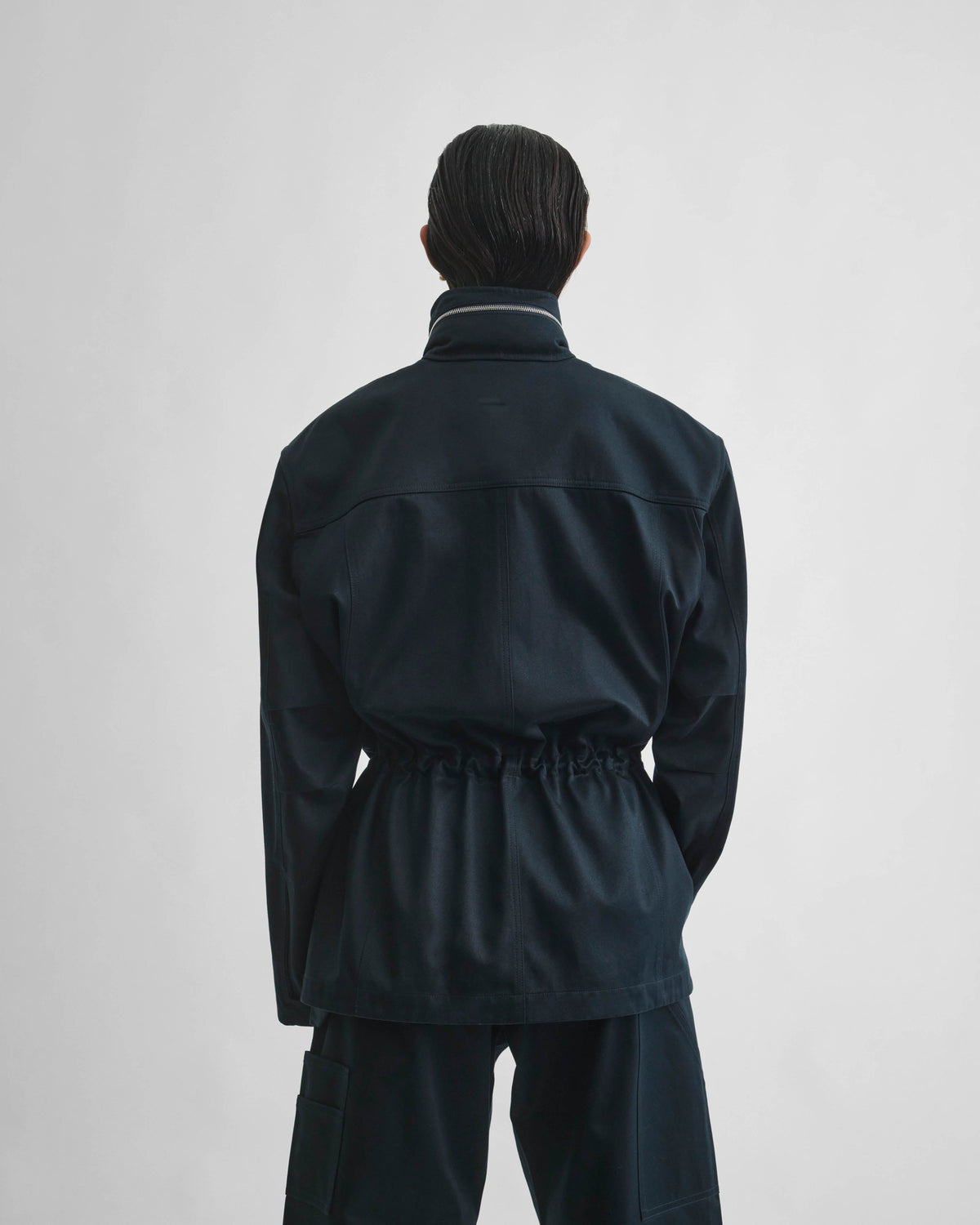 Back view of model wearing UTILITY JACKET in black ink cotton
