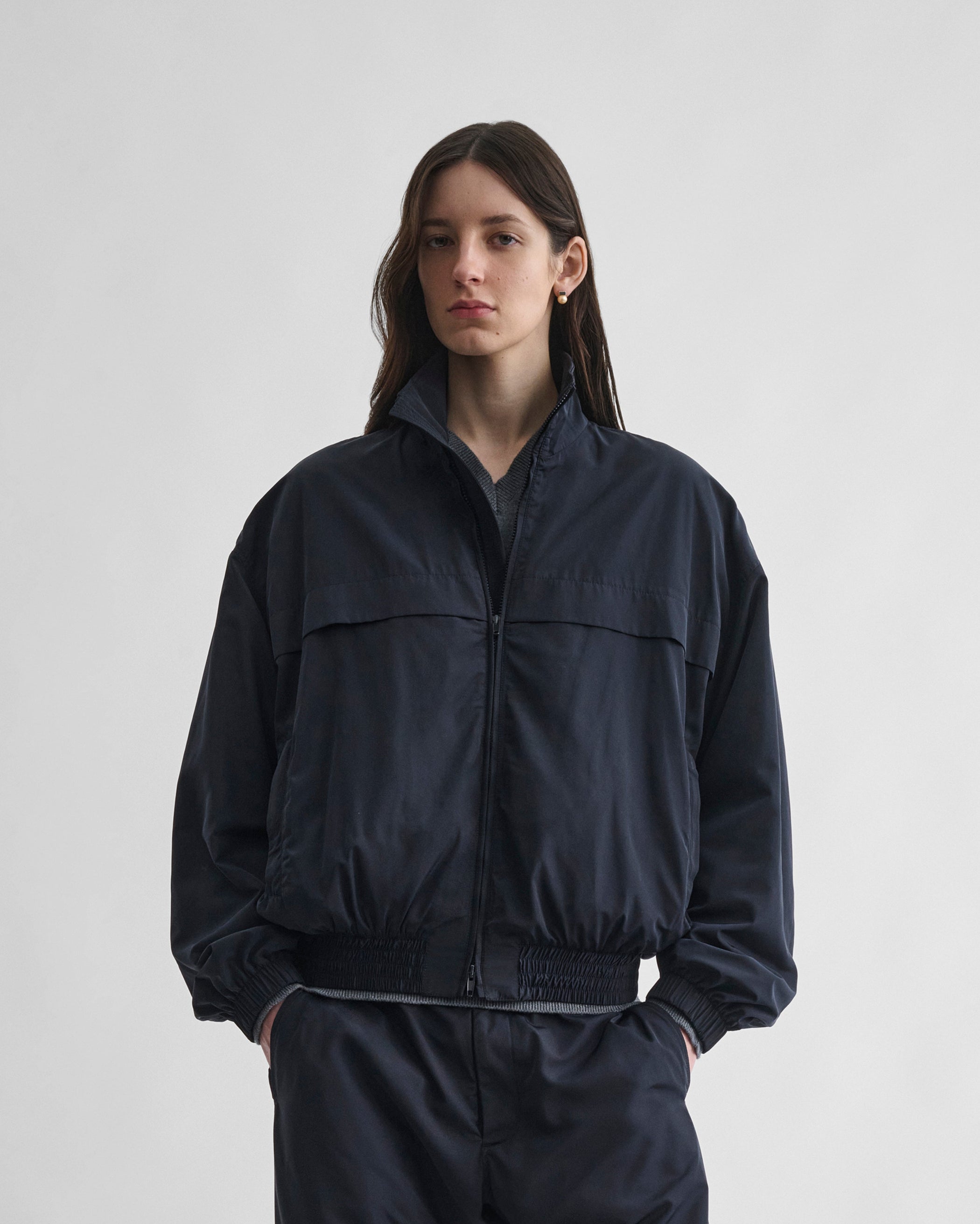 Front view of model wearing WINDBREAKER in dark navy polyester